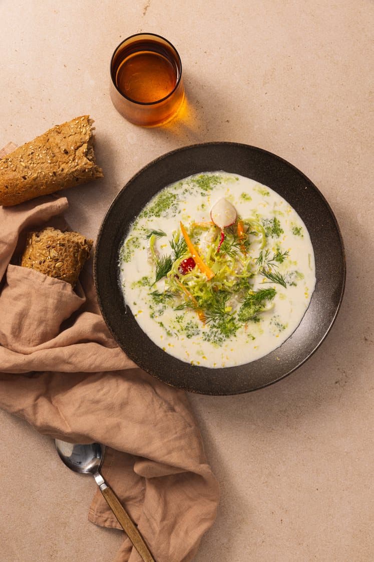 Kremet fiskesuppe med hysefilèt og purre, servert med bagetter og sitron- og dilltopping 