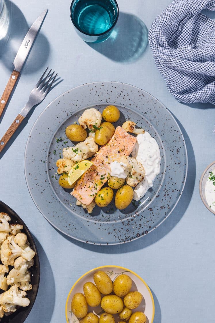 Ovnsbakt laks med poteter og smørstekt blomkål, servert med eple- og gressløkdressing