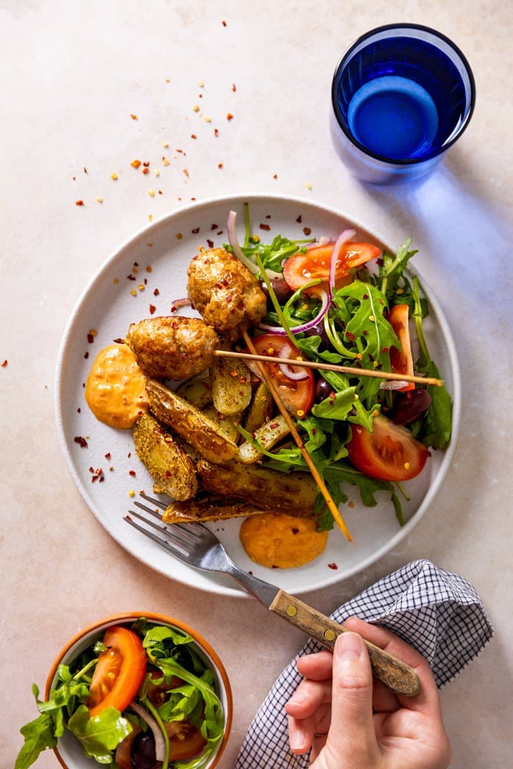 Grillede kebabspyd med middelhavspoteter, tomat- og ruccolasalat, oliven og ajvardressing