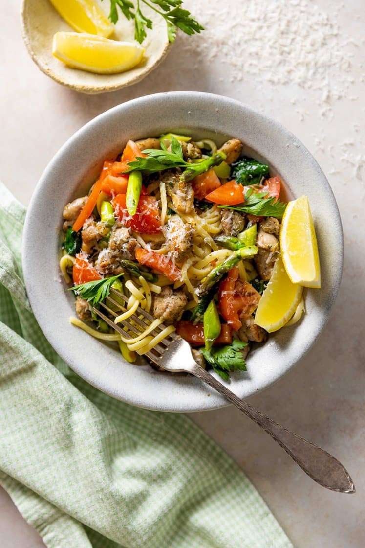 Sommerlig pasta med stekt kylling i kryddersmør, asparges og lime