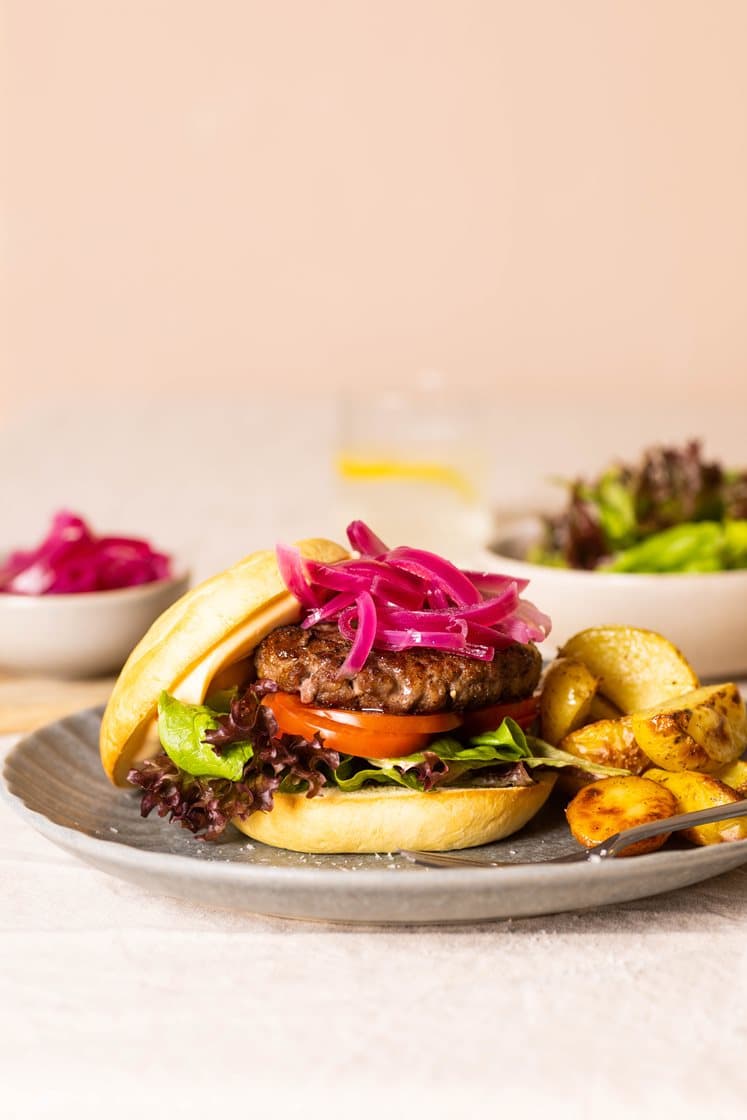 Klassisk hamburger med grønn salat, syltet rødløk, chilimajones og potetkløfter