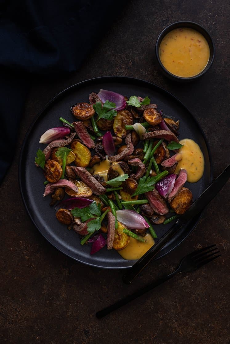 Smørstekt minuttbiff og bakt løk, servert med aromasopp, aspargesbønner og chili-bearnès