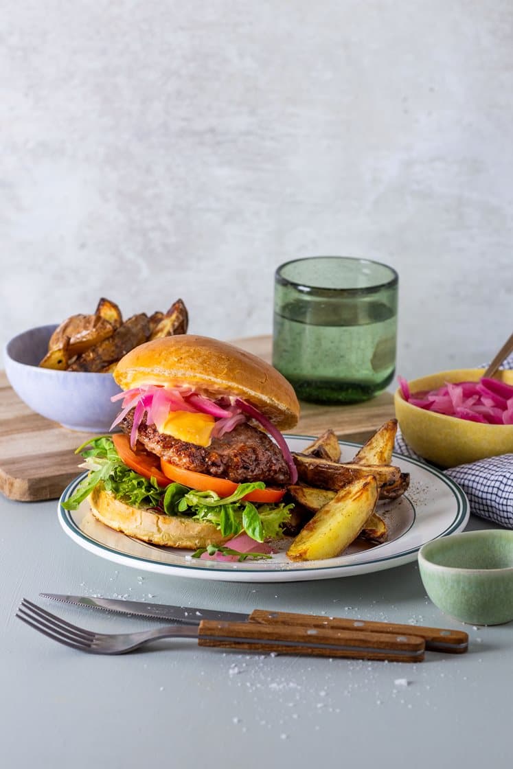 Hjemmelaget hamburger med grønn salat, syltet rødløk, chilimajones og potetkløfter