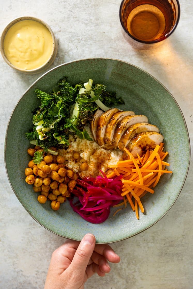 Cosucous- og kikertbowl med kylling i soya- og ingefærsjy, sprøstekt grønnkål og curry- og mangodressing