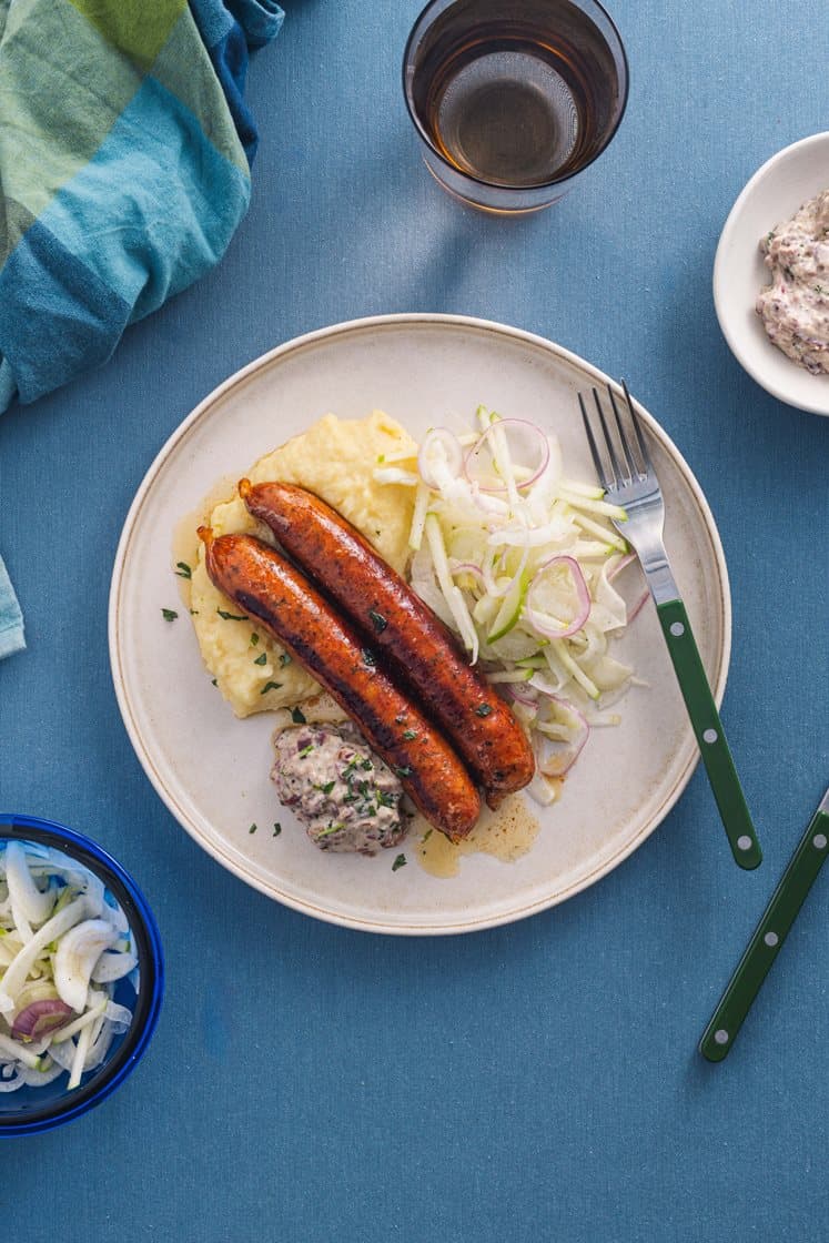 Black garlic-pølse med eple- og fennikelslaw, karamelisert løkkrem og potetmos