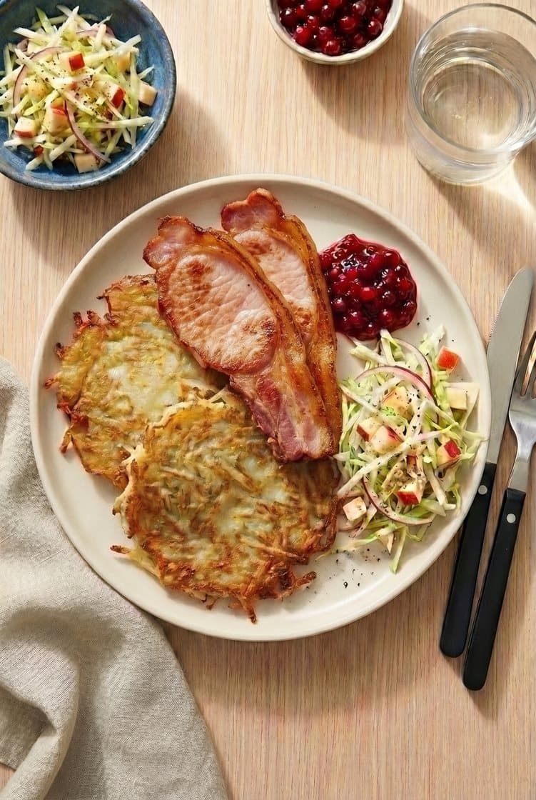 Svensk raggmunk med eple- og spisskålsalat, stekt bacon og rørte tyttebær