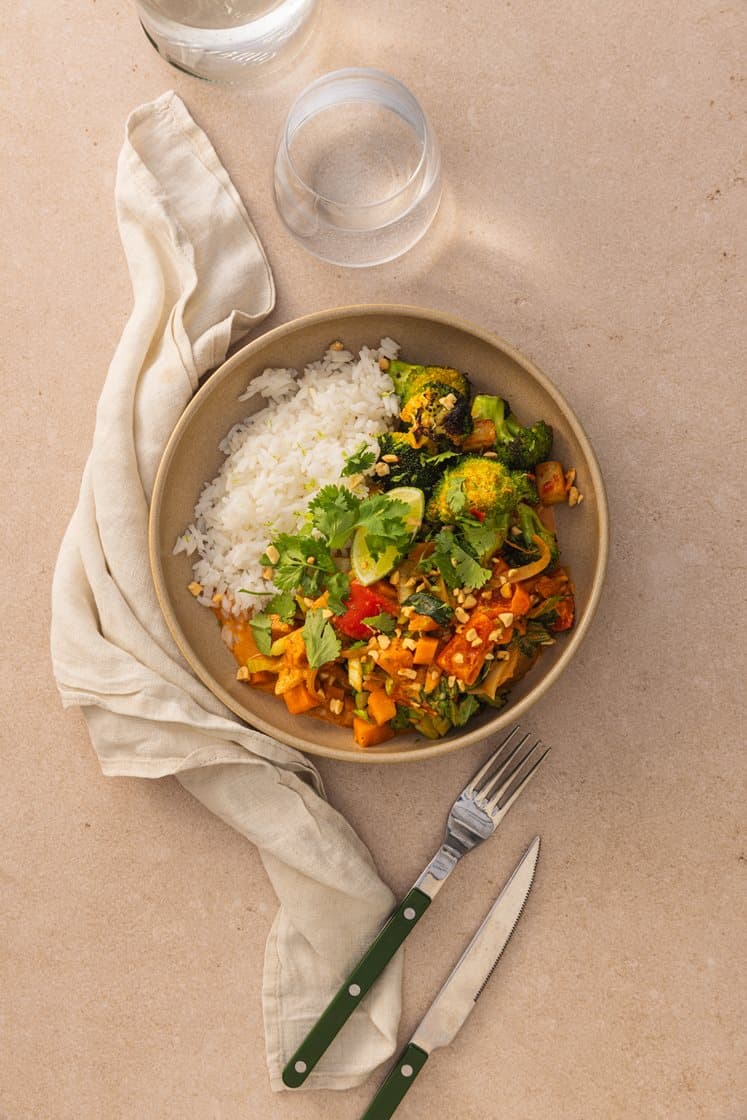 Massaman grønnsakscurry med ris og chilistekt brokkoli, toppet med peanøtter og koriander