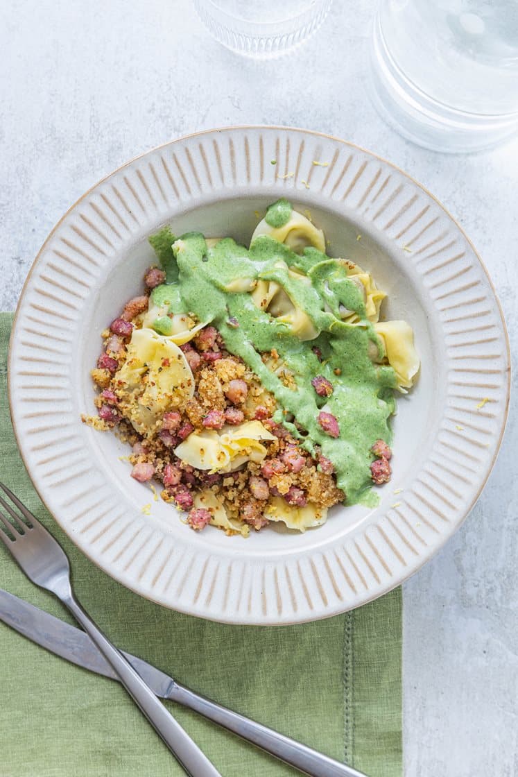 Steinsopptortelloni med kremet purreløk, servert med sprøstekt bacon-topping