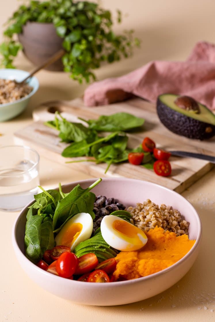 Buddha bowl med søtpotetmos, byggkorn, avokado og smilende egg