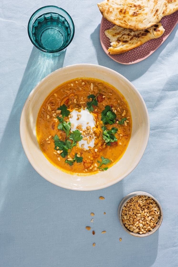 Indisk linsesuppe med koriander og yoghurt, servert med nanbrød og nøtter