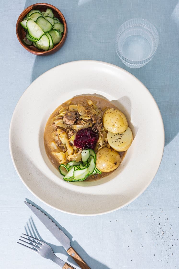 Svensk kålmaja med kokte poteter, agurksalat og rørte tyttebær