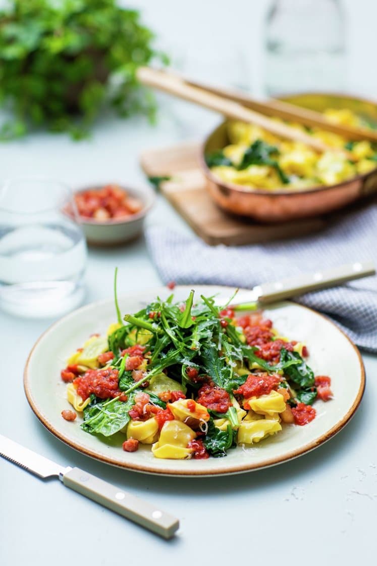 Ost- og skinketortelloni med sprøstekt bacon og tomatsaus, toppet med Grana Padano