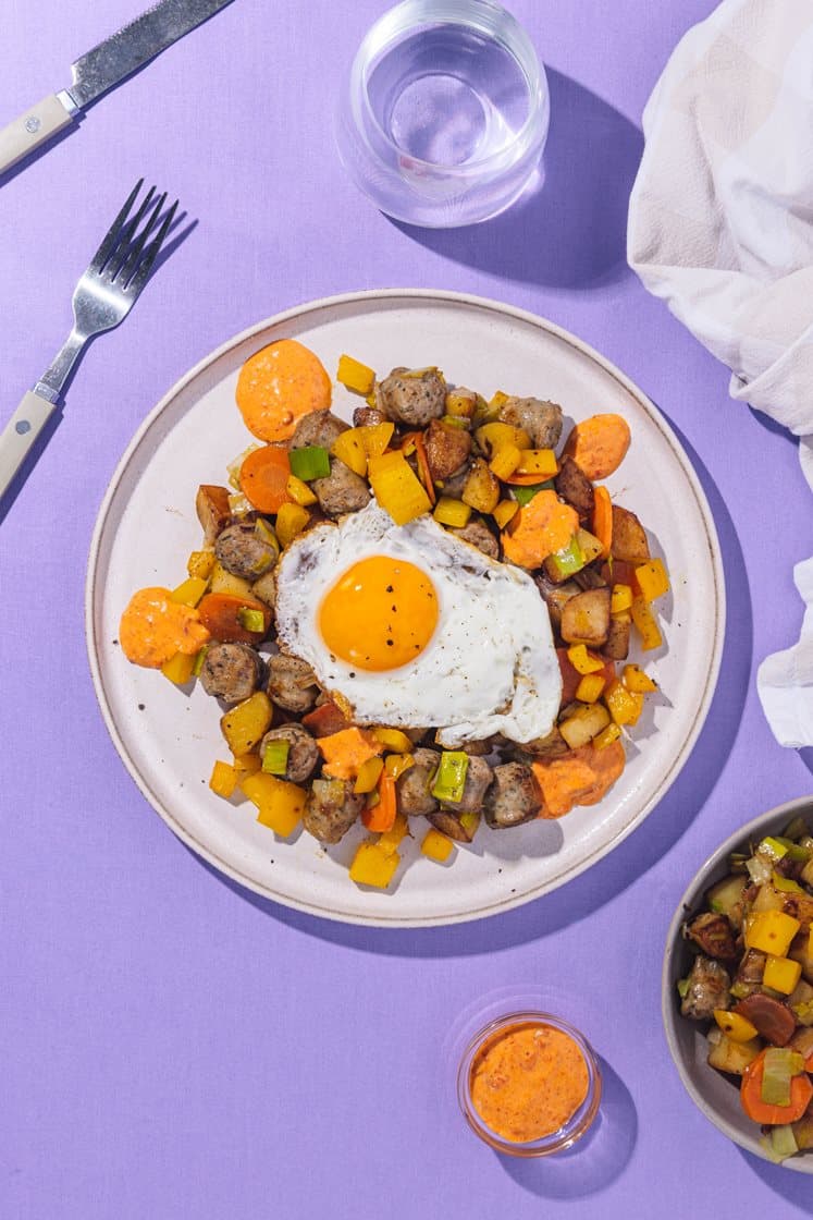 Pytt-i-panne med salsicciapølser, purre, speilegg og ajvardressing