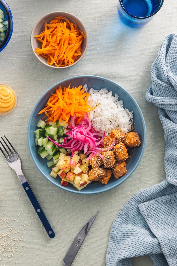Laksepoke med ris, agurk, syltet rødløk og teriyakidressing, toppet med chilimajones