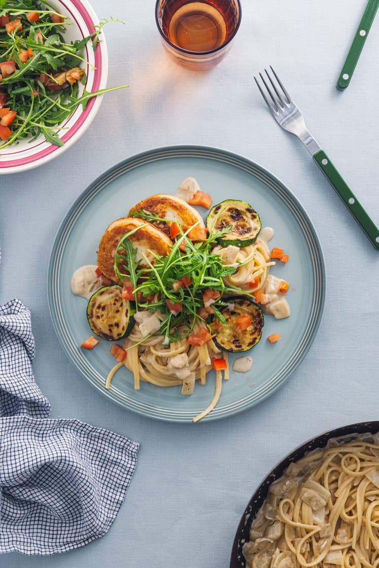 Fiskekaker og pasta i kremet saus med stekt squash, ruccola og tomat