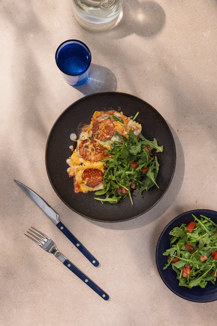 Gratinert ravioli med ricotta og spinat, tomatsaus og pepperoni, servert med ruccolasalat