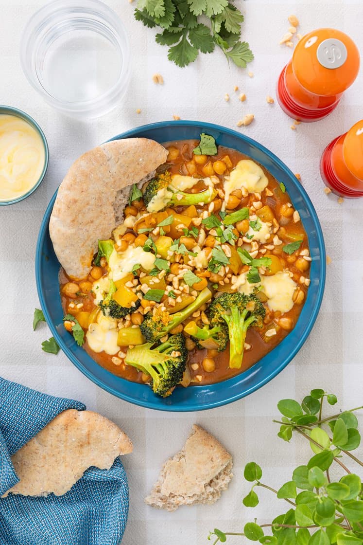 Curry med kikerter og garam masala, fullkornspita, mangodressing og peanøtter