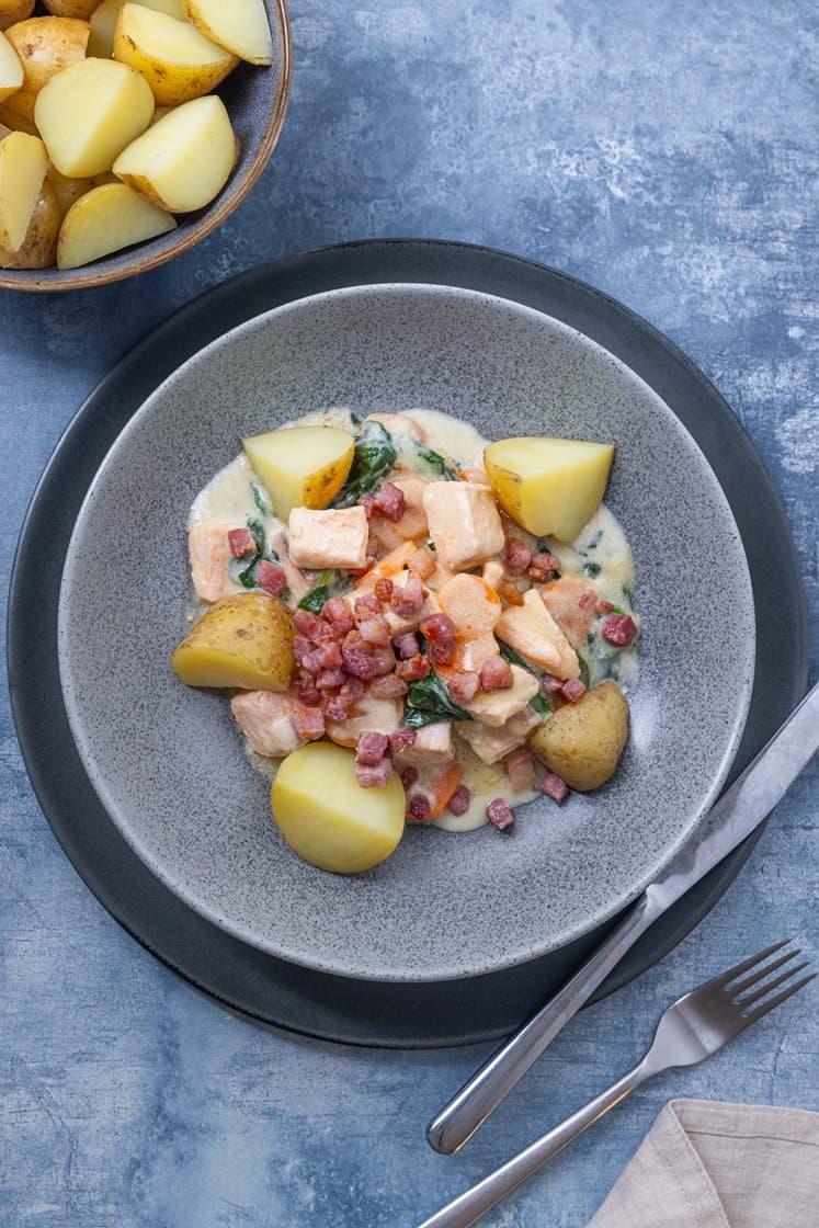 Laksepanne i kremet saus med spinat og sprøstekt bacon, servert med kokte poteter