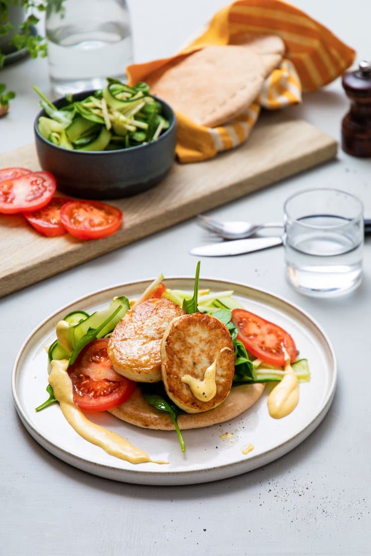 Fiskekakesandwich i fullkornspita med spinat og curry- og mangodressing