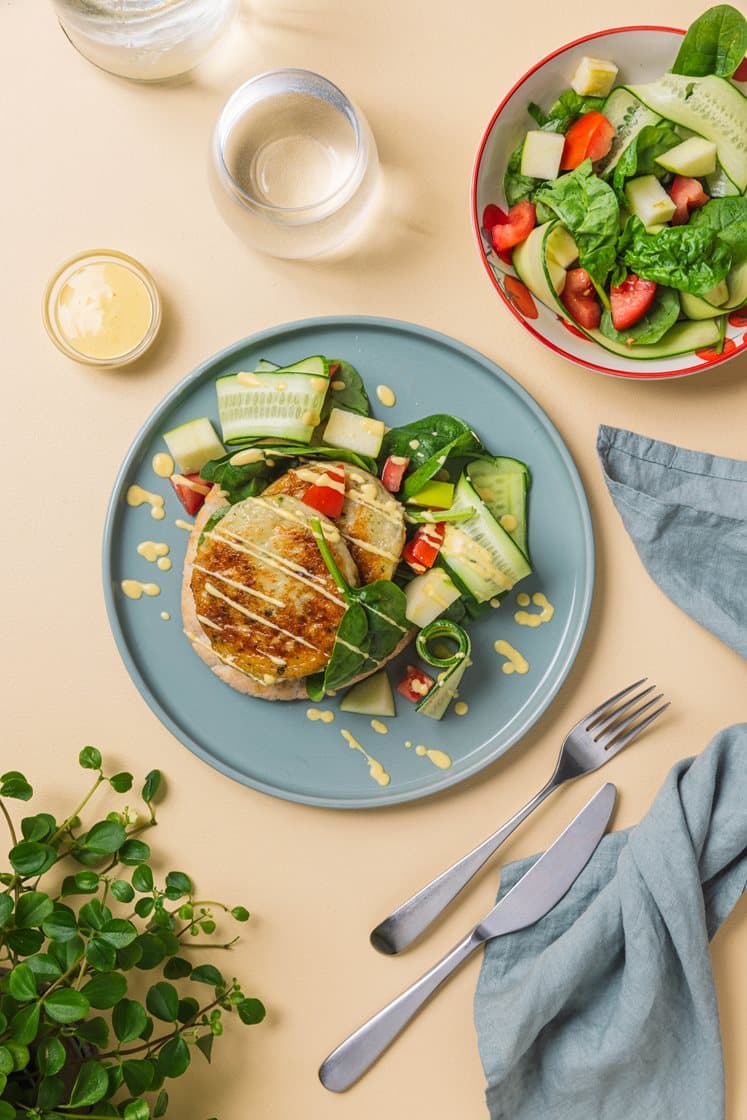 Fiskekakesandwich i fullkornspita, med spinat og curry- og mangodressing