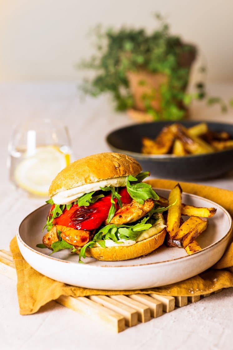 Burger med krydderstekt kylling og urteaioli, ovnsbakte potetstaver og paprika
