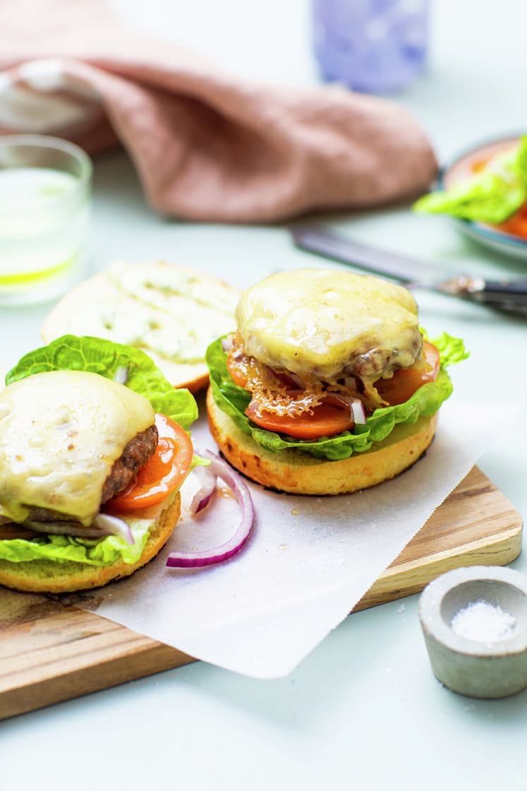 Saftig burger i briochebrød med ost, aioli, frisk salat og tomatskiver 