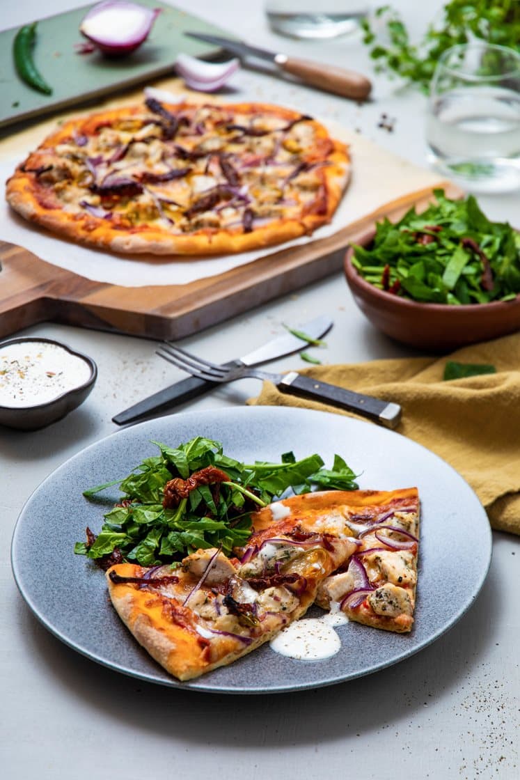 Italiensk pizza med kylling, tomat, rødløk og spinat