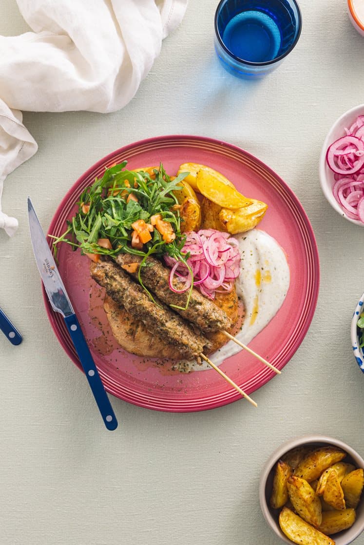 Adana-kebab med potetbåter, råmarinert løk, yoghurtdressing og varme brød