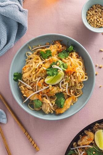 Pad thai med kyllingfilet, risnudler og bønnespirer, toppet med hakkede peanøtter og koriander