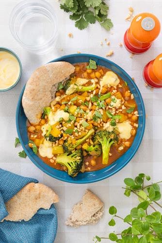 Curry med kikerter og garam masala, fullkornspita, mangodressing og peanøtter