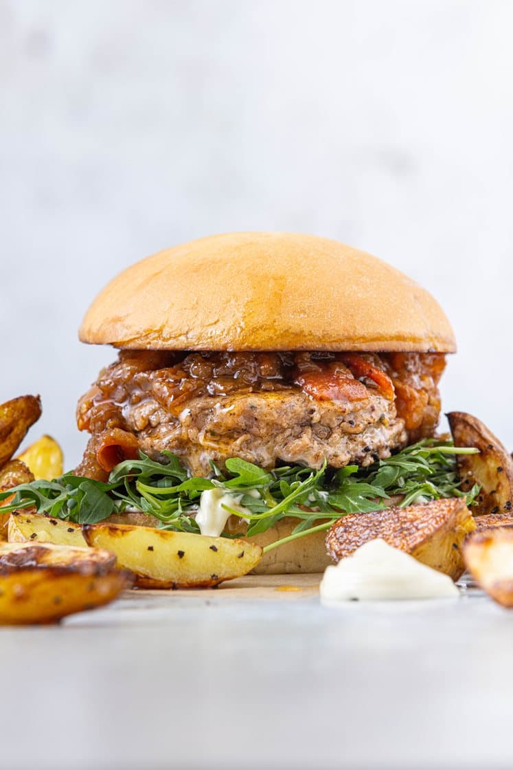 Salsicciaburger med tomatkompott og ruccola, servert med potetbåter og aioli