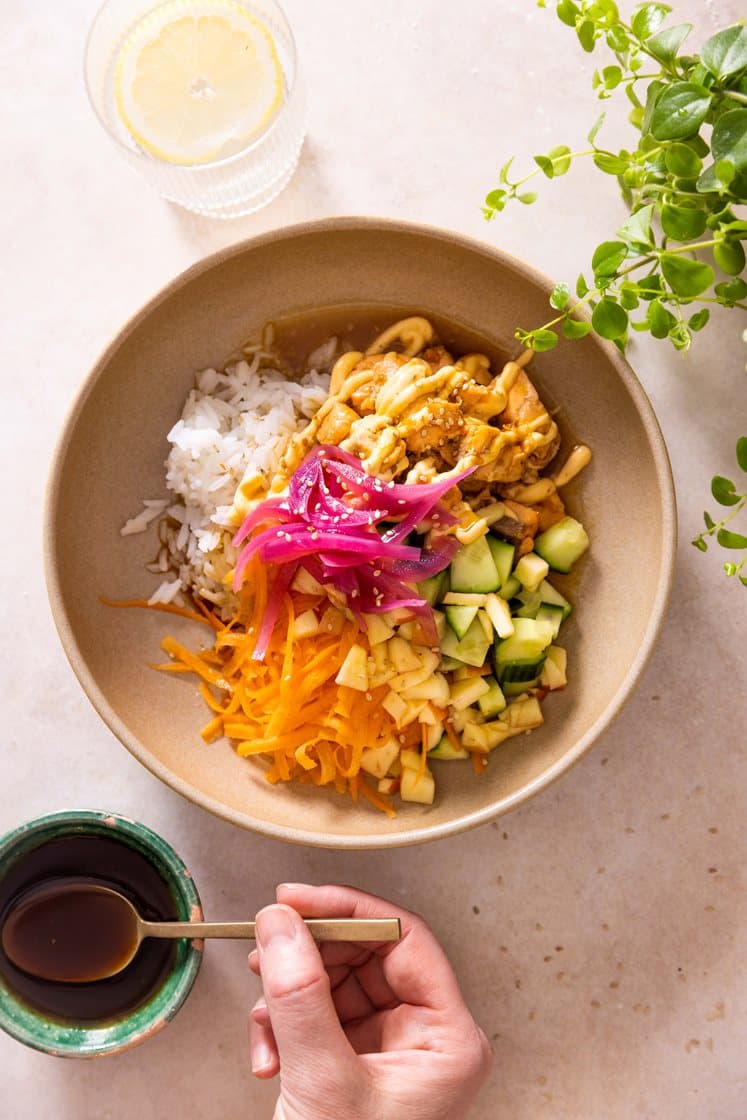 Laksepoke med ris, agurk, syltet rødløk og teriyakidressing, toppet med chilimajones