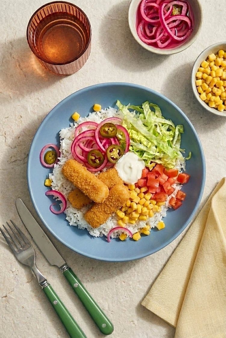 Bowl med fish taco-sticks og ris, jalapeño-syltet rødløk, mais og rømme