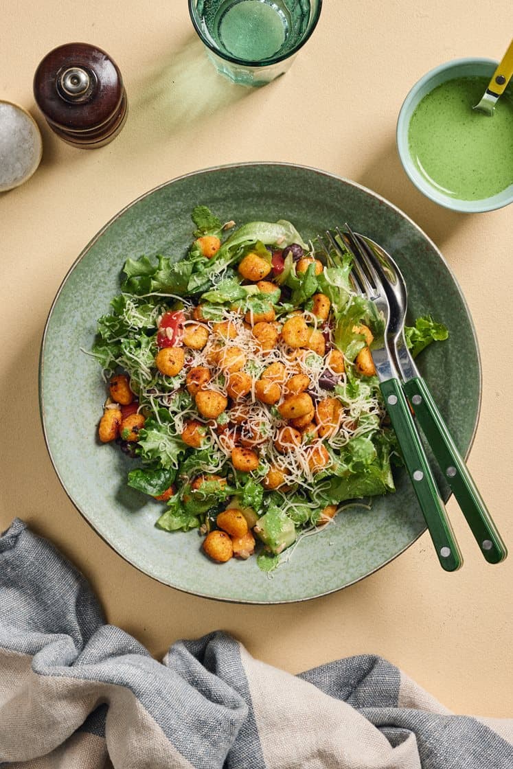 Krydret sprø gnocchi med frisk salat, grønn dressing og revet ost
