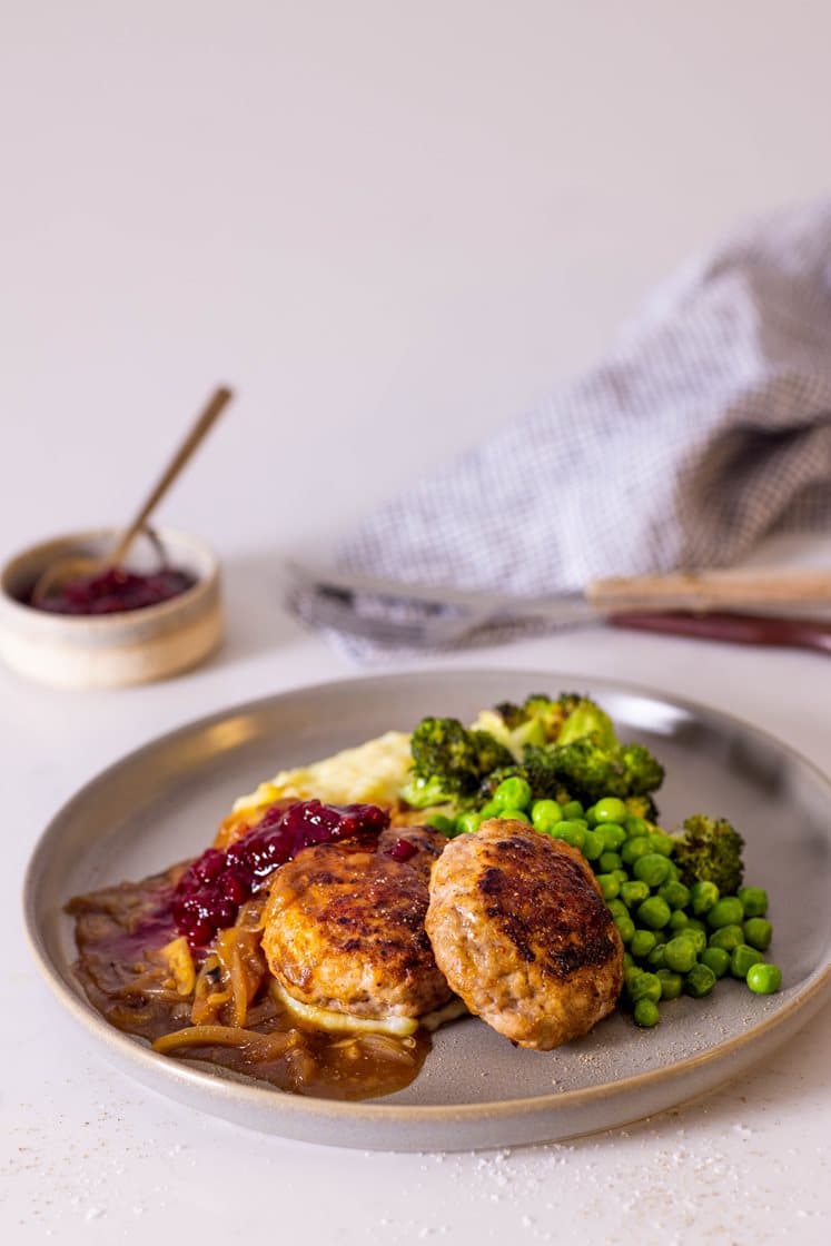 Salsicciakarbonader med potetpuré, løksjy, grønne erter og rørte tyttebær